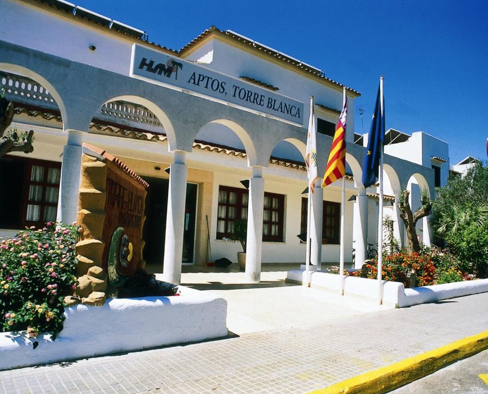 un gran edificio con banderas delante en HSM Club Torre Blanca, en Sa Coma