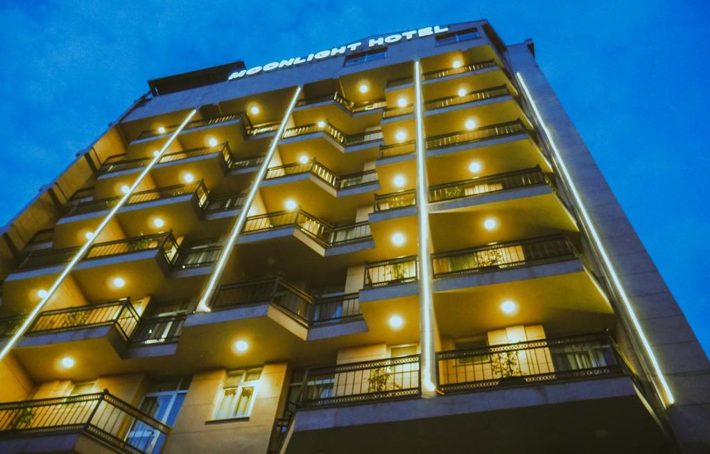 un edificio giallo alto con balconi e luci di Moonlight Hotel Addis Ababa ad Addis Abeba