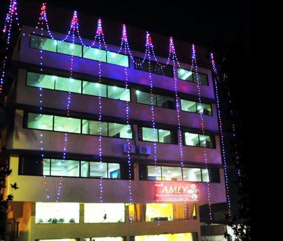 a building with purple lights on the side of it at Saiesh International Hotel in Mapusa