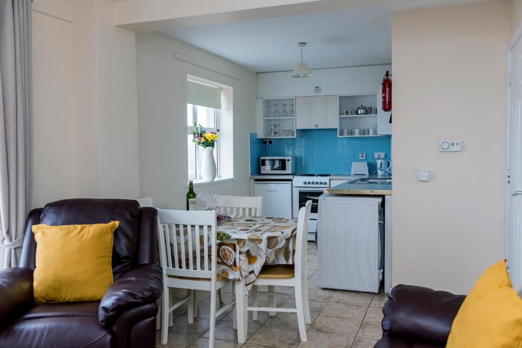 a living room with a couch and a table and a kitchen at Marine Court Ground Floor Apartment in Bundoran