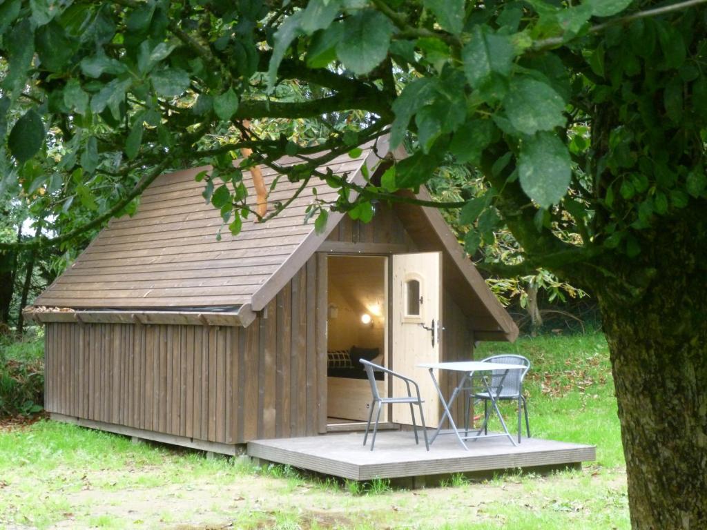 a shed with two chairs and a table in it at Les cabanes de Kerellou in Plouigneau