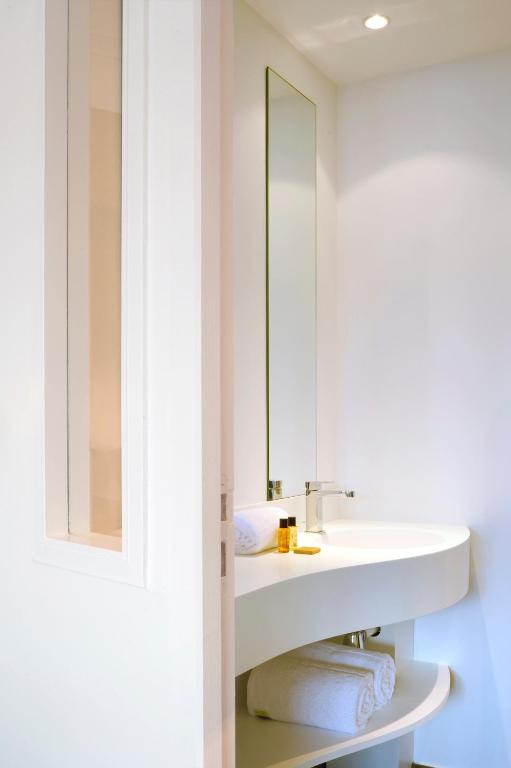 a bathroom with a sink and a mirror at L’Échappée Belle in LʼIsle-Jourdain