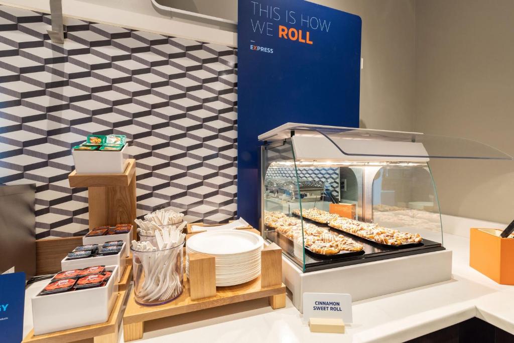 a display case with donuts and other pastries at Holiday Inn Express & Suites - Green Bay East by IHG in Green Bay