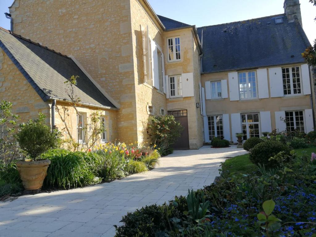 une grande maison avec une passerelle devant elle dans l'établissement Hôtel particulier "le clos de la croix", à Bayeux