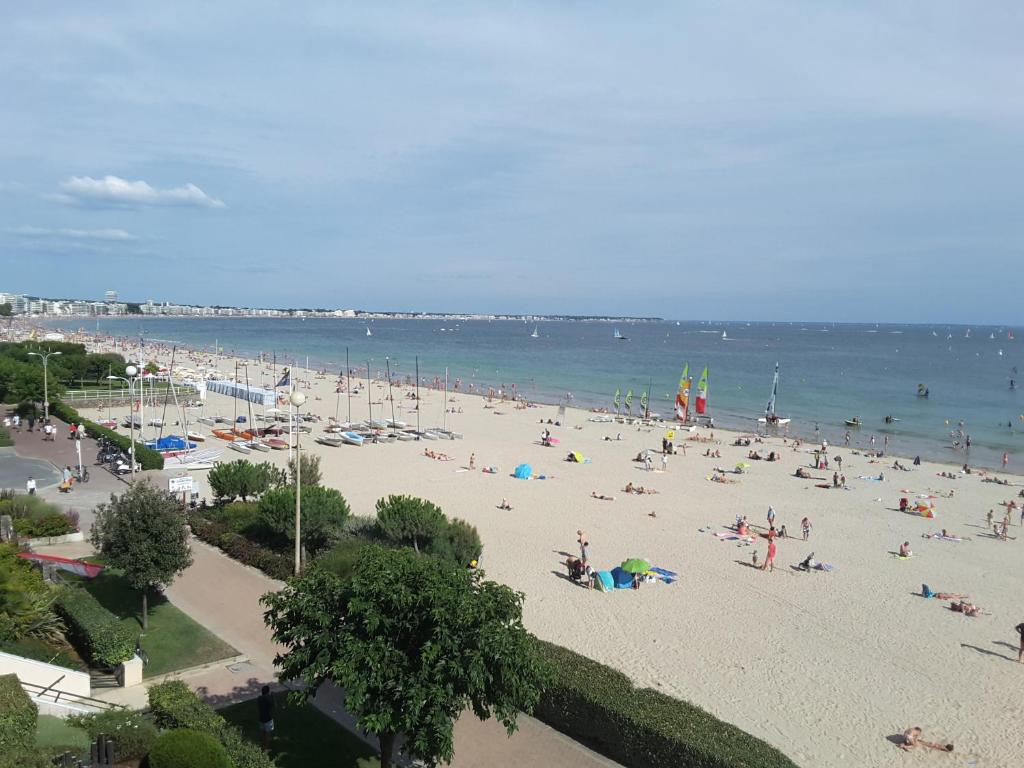 uma praia com muita gente e o oceano em LOUEURDAPPART - Studio Terrasse, accès direct Plage Benoit em La Baule