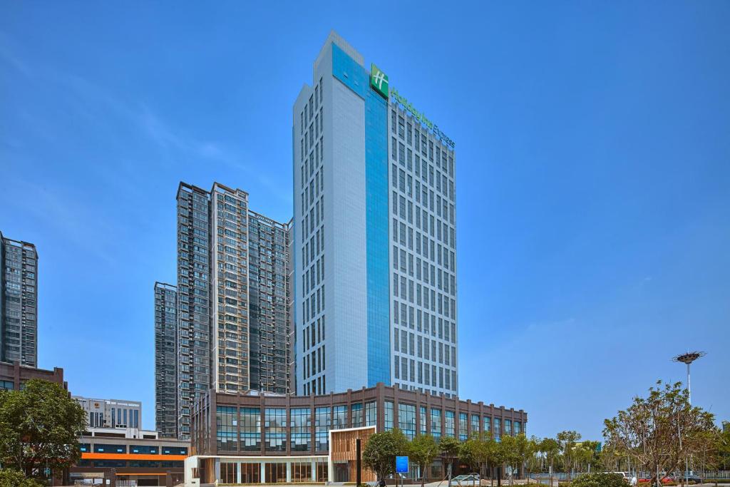 Un alto edificio blu di fronte a qualche alto palazzo di Holiday Inn Express Luoyang Yichuan, an IHG Hotel a Yichuan