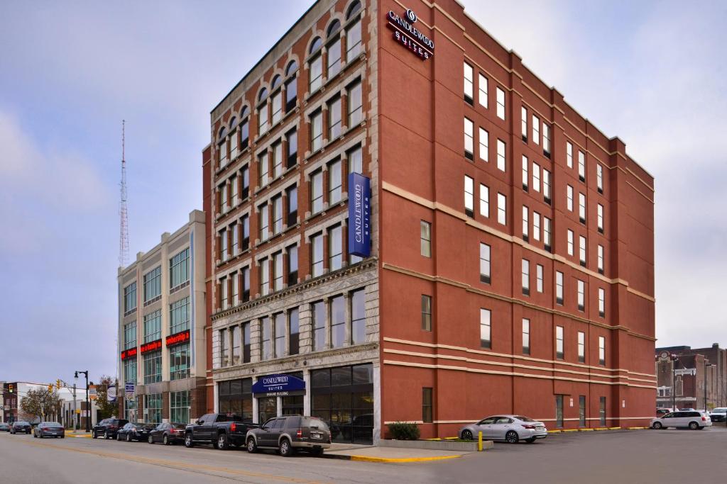 a large brick building with cars parked in front of it at Candlewood Suites Terre Haute, an IHG Hotel in Terre Haute