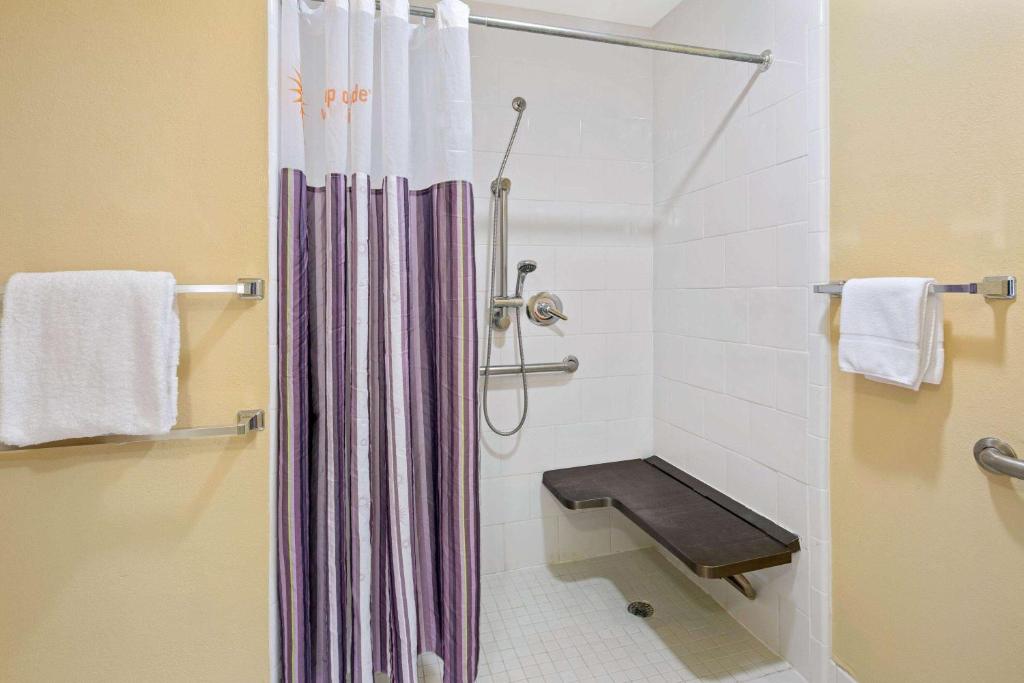a bathroom with a shower with a shower curtain at La Quinta Inn & Suites by Wyndham Sunrise in Sunrise