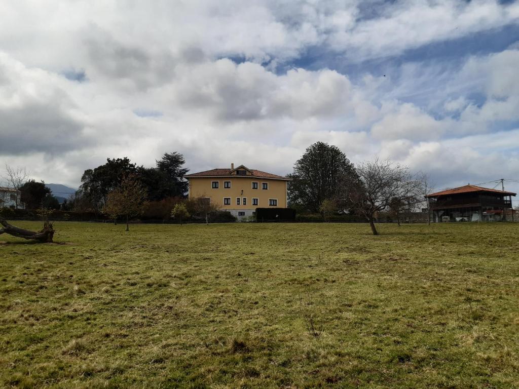 a large field with a house in the background at Hotel Hontoria in Hontoria