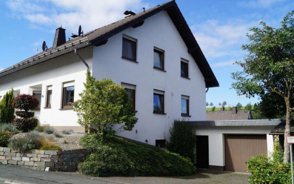 a white house with a garage at de Vinkenborg nabij Winterberg in Winterberg