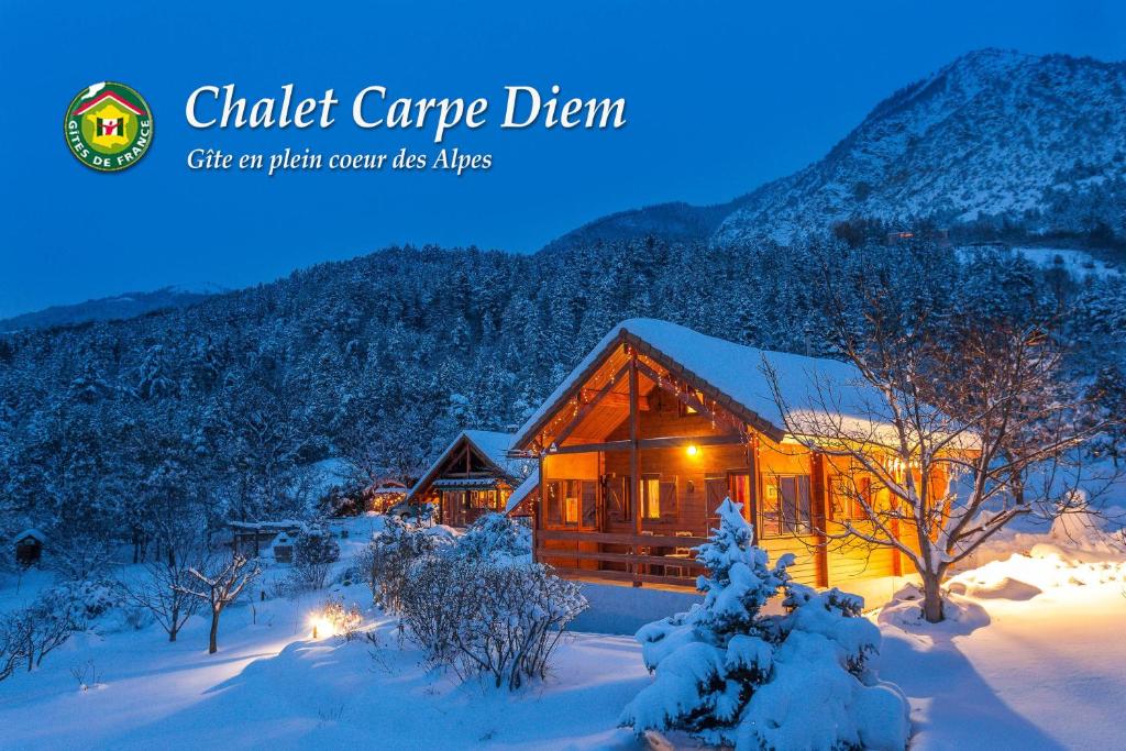 una cabaña de madera en la nieve por la noche en Chalet Carpe Diem, en La Bâtie-Neuve