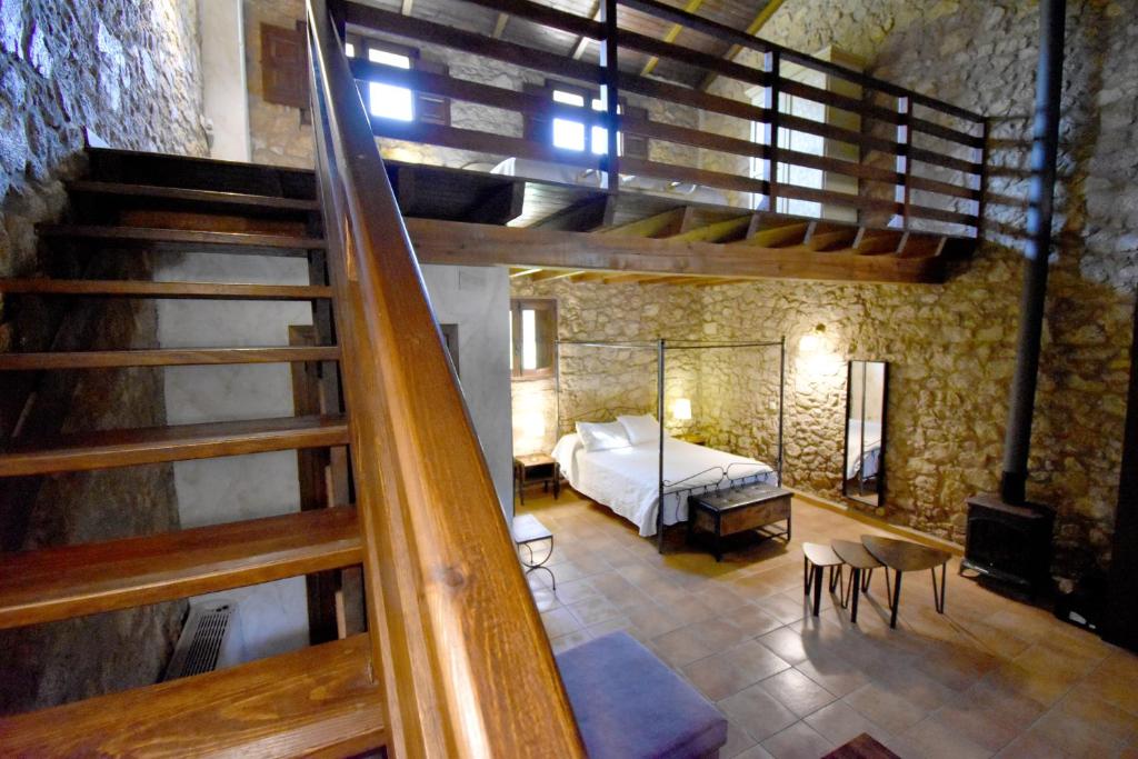 1 dormitorio con 1 cama y una escalera en una habitación en HOTEL RURAL A VELHA FABRICA, en Valverde del Fresno