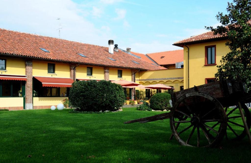 a bench in the grass in front of a building at Hotel Cascina Marisa in Opera