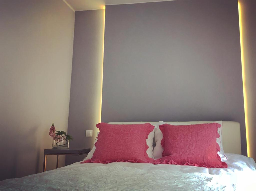 - un lit avec un oreiller rouge dans l'établissement Art Apartament, à Zielona Góra