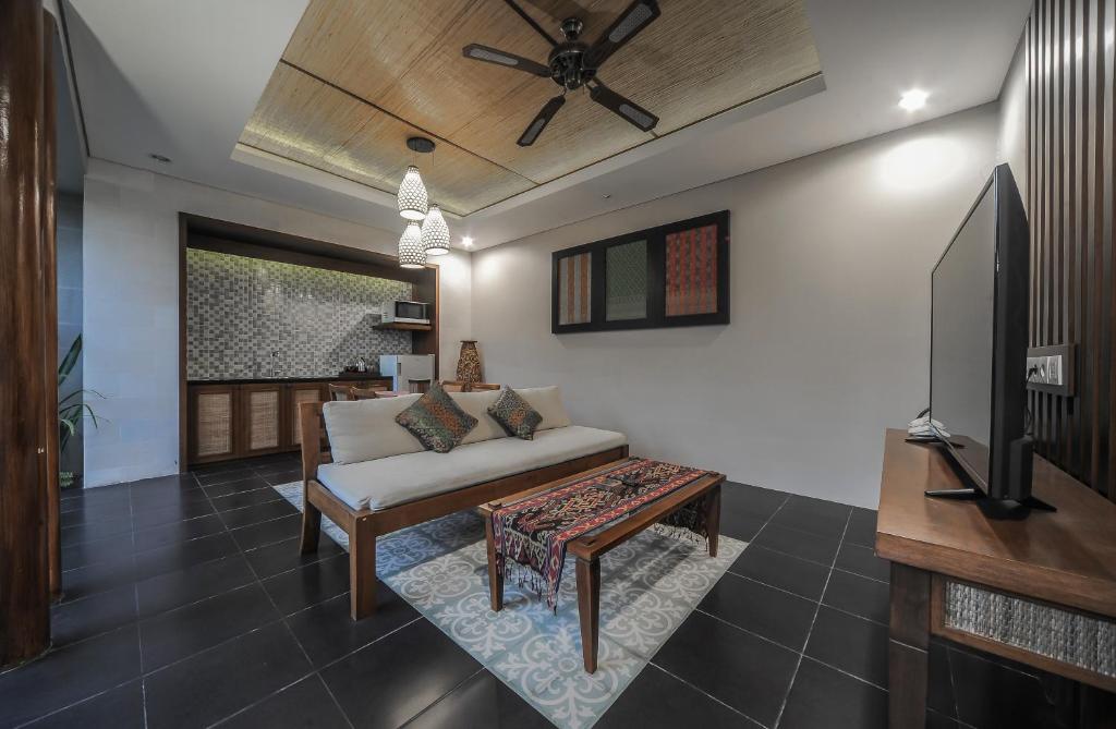 a living room with a couch and a tv at Gaing Mas Jimbaran Villas by Gaing Mas Group in Jimbaran