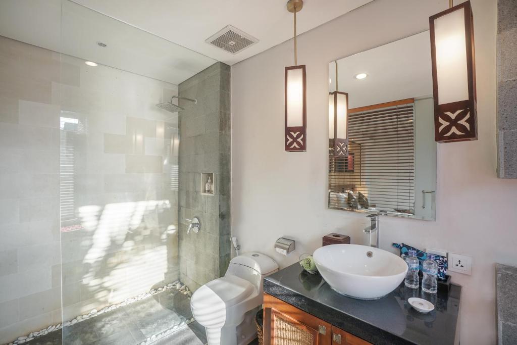 a bathroom with a toilet and a sink and a shower at Gaing Mas Jimbaran Villas by Gaing Mas Group in Jimbaran