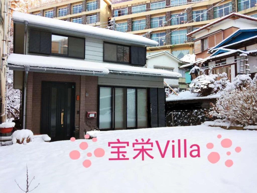 a house with a sign in the snow at 宝栄 villas lakeside in Fujikawaguchiko