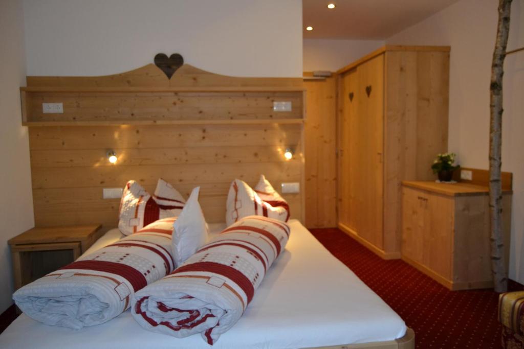 un letto con testiera in legno e cuscini sopra di Häuslerhof a Maranza
