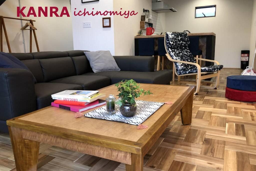 a living room with a couch and a table with books at KANRA ichinomiya in Ichinomiya