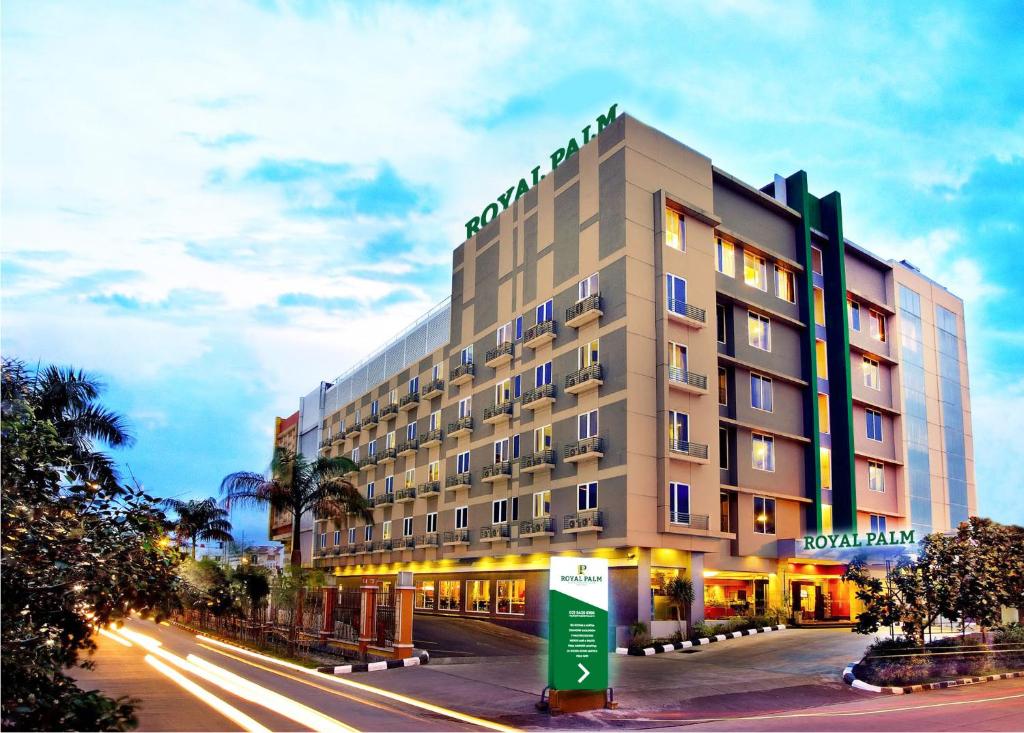 Royal Palm Hotel & Conference Center Cengkareng في جاكرتا: مبنى الفندق على شارع المدينة ليلا