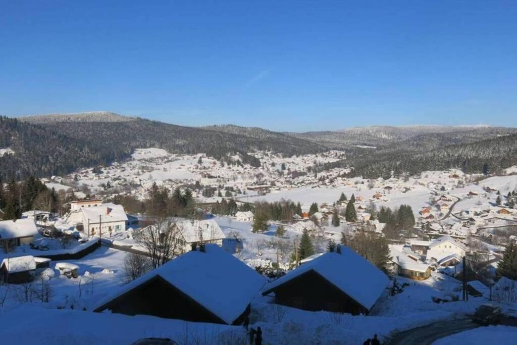 a town covered in snow with mountains in the background at Studio La Belle Vue in Xonrupt-Longemer