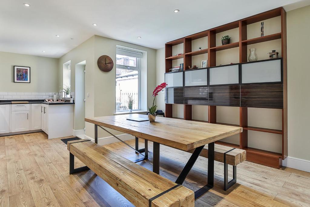 a kitchen with a wooden table and a dining room at Refurbished Central Premium Property in Sheffield