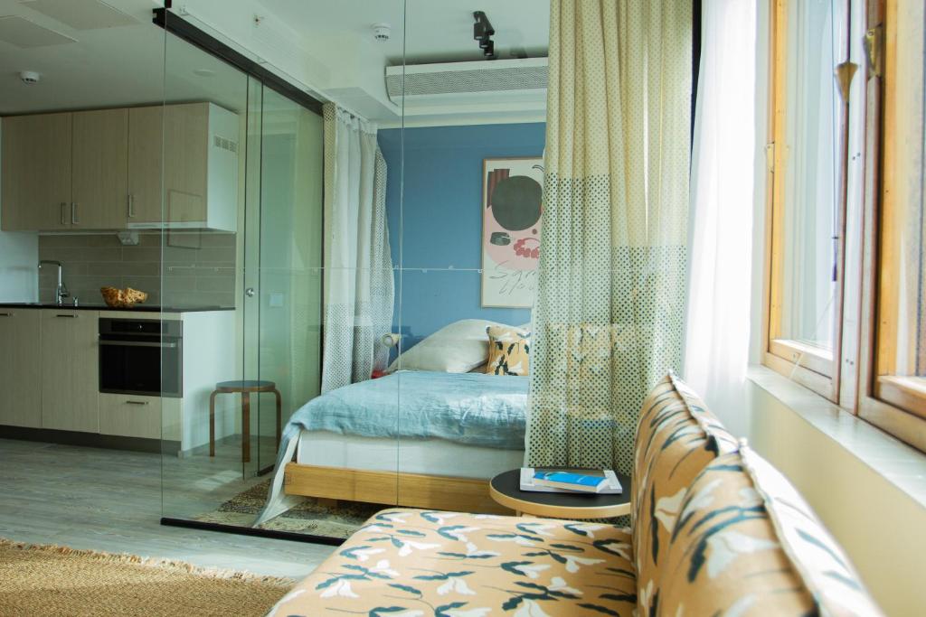 una camera con letto e una cucina con specchio di Noli Sörnäinen a Helsinki