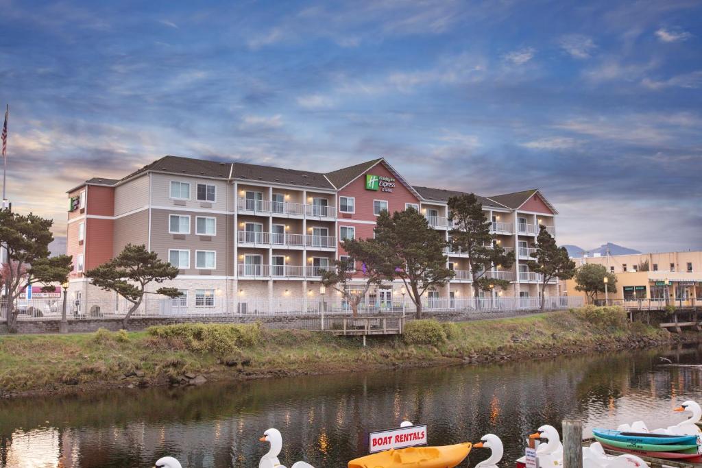 um grupo de cisnes na água em frente a um hotel em Holiday Inn Express Hotel & Suites Seaside Convention Center, an IHG Hotel em Seaside