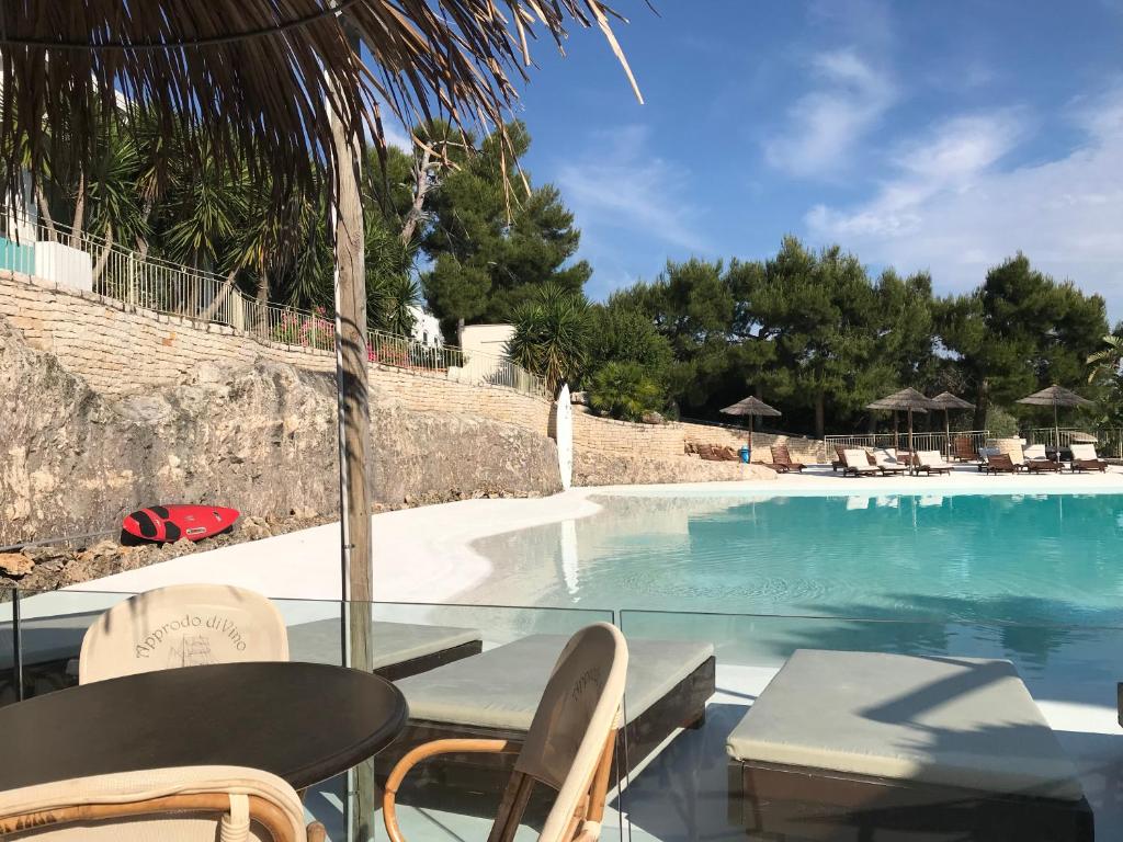 uma vista para uma piscina com cadeiras e uma mesa em Viestemare Resort & SPA em Vieste