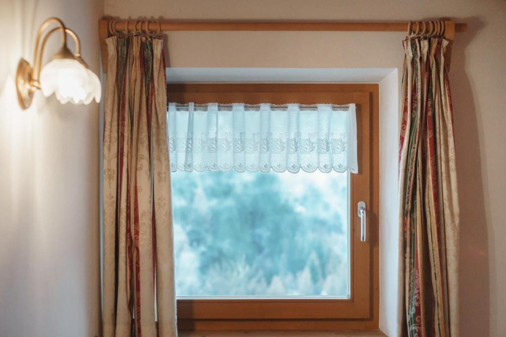 okno z zasłoną w pokoju w obiekcie Residence Karnutsch w mieście Santa Valpurga