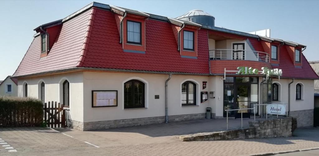 ein rotes und weißes Gebäude mit rotem Dach in der Unterkunft Hotel Alte Apotheke in Bad Dürrenberg