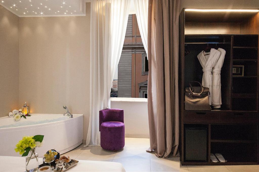 een badkamer met een ligbad en een wastafel bij Roman Holidays Boutique Hotel in Rome