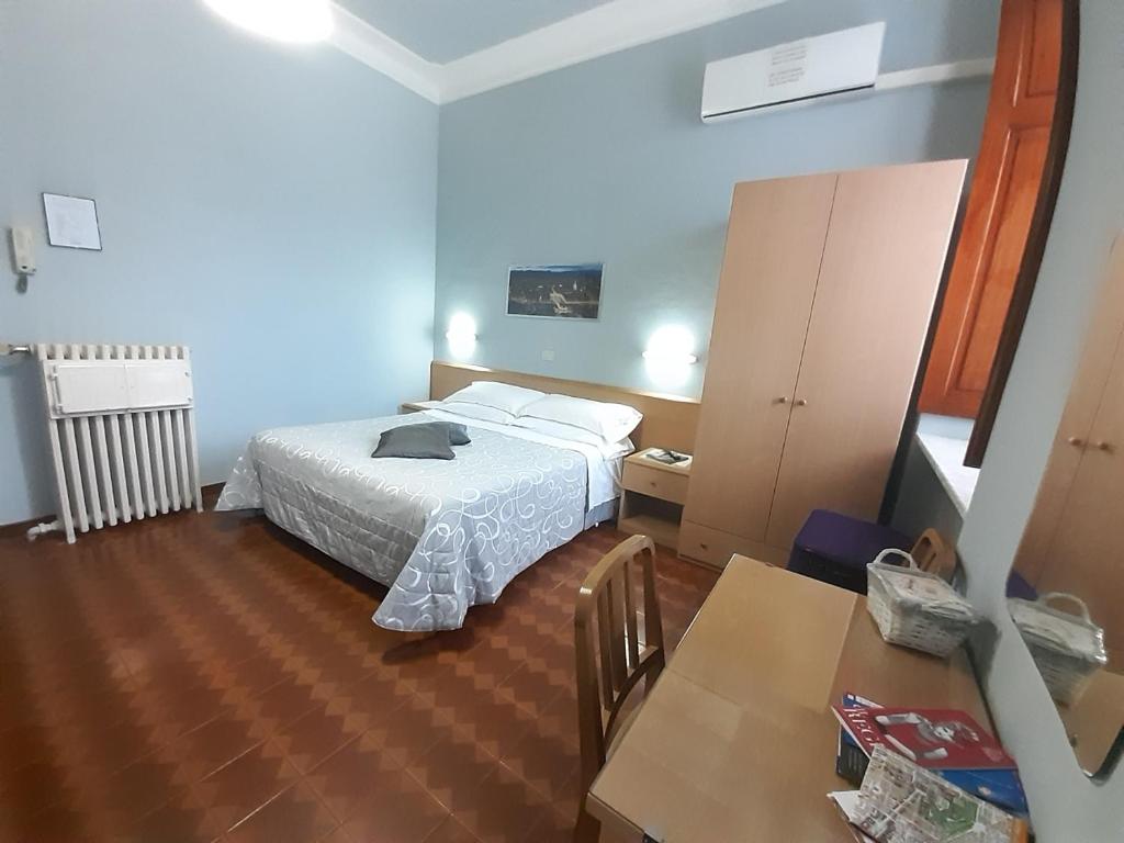 a bedroom with a bed and a table in a room at Albergo in Centro in Turin