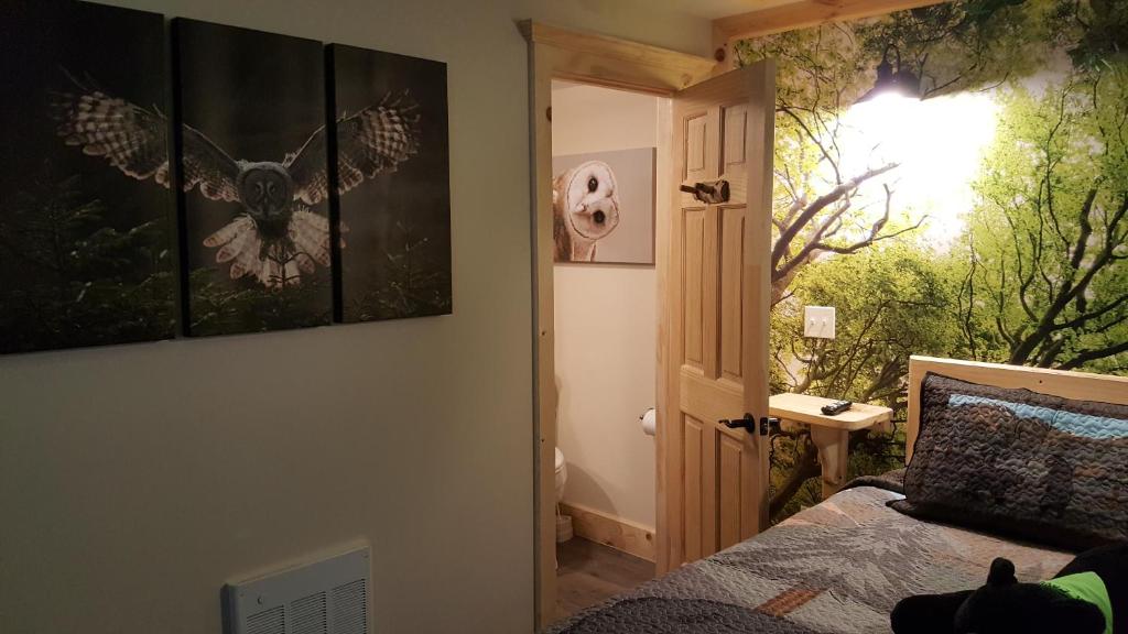 a bedroom with a bed and a window with a butterfly painting at Bear Cove Inn in Saint Ignace