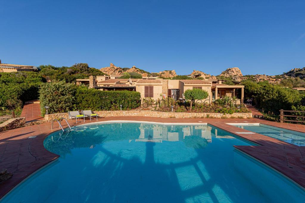 una gran piscina frente a una casa en Ginepro Arancione, en Li Valcaggi