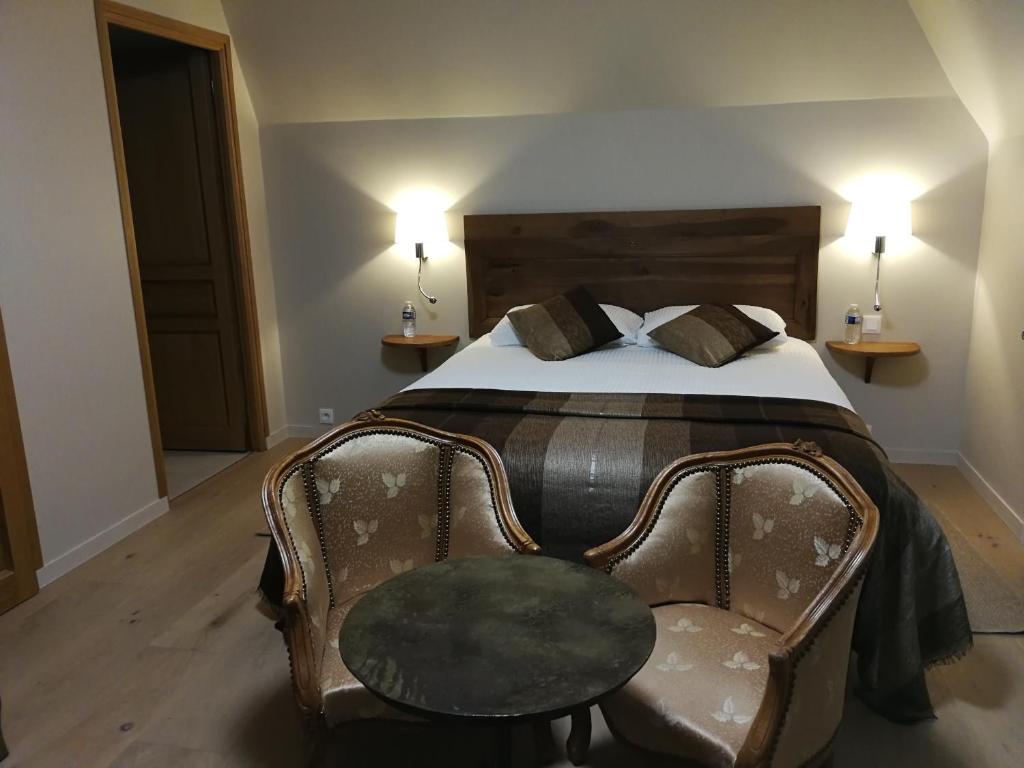 1 dormitorio con 1 cama, 1 silla y 2 lámparas en Auberge du Vieux Tour Le Manoir, en Canapville