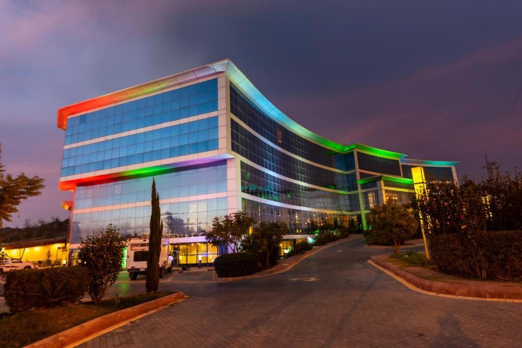 a large building with green and blue windows at night at National Park Hotel in Baljurashi