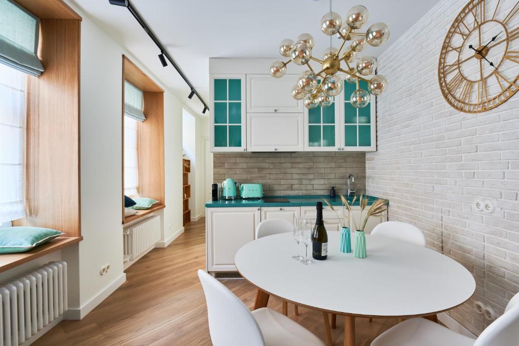 a kitchen with a white table and chairs and a clock at Dream Boutique Apartments in Riga