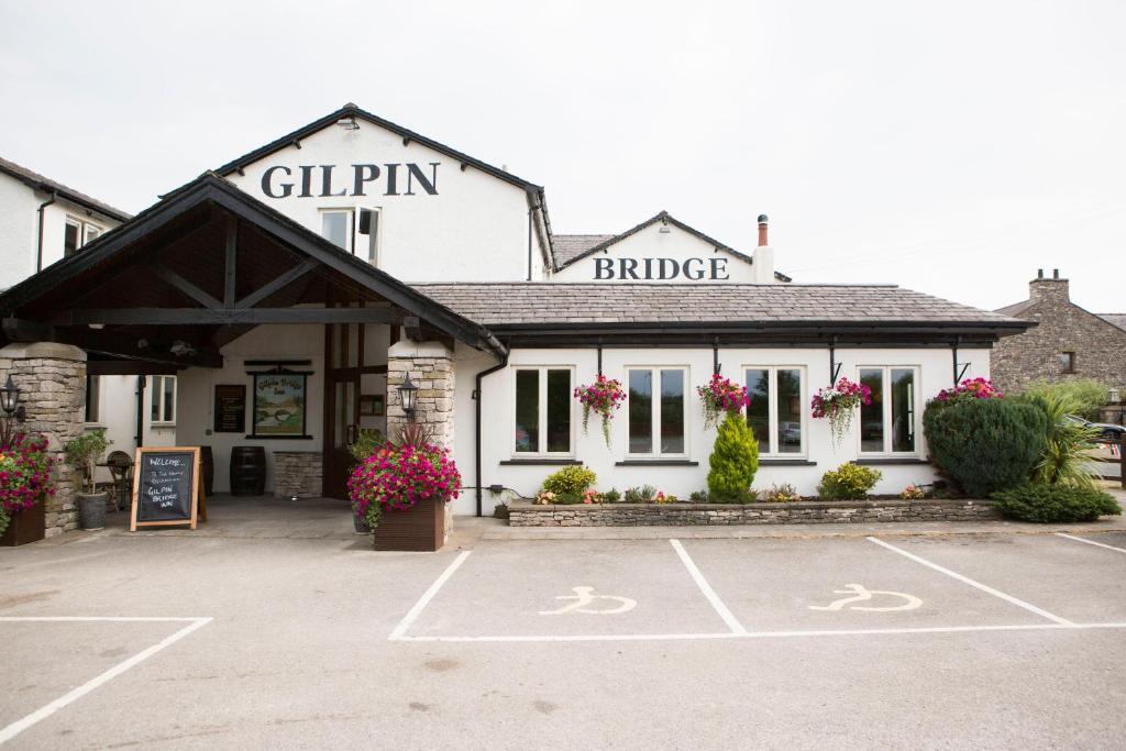 un bâtiment avec un parking en face de celui-ci dans l'établissement Gilpin Bridge Inn, à Kendal