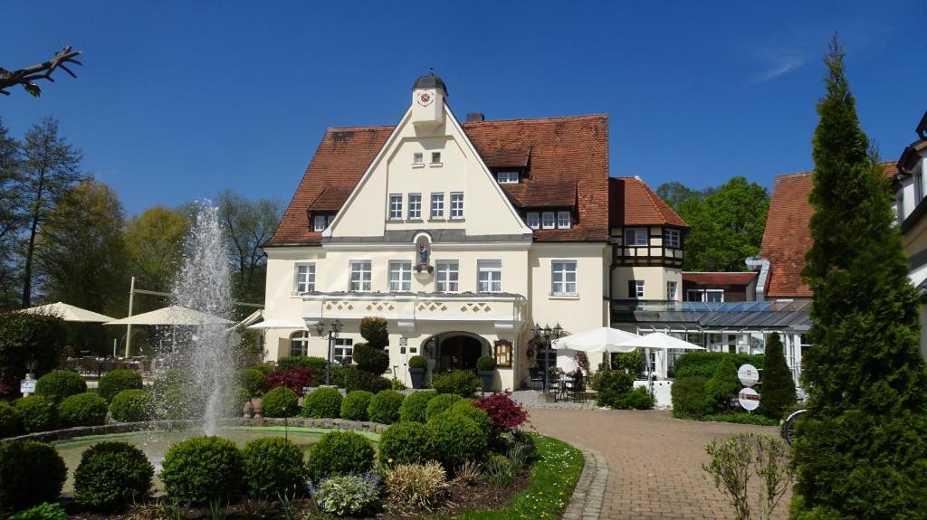 a large white building with a fountain in a garden at Drahthammer Schlößl in Amberg
