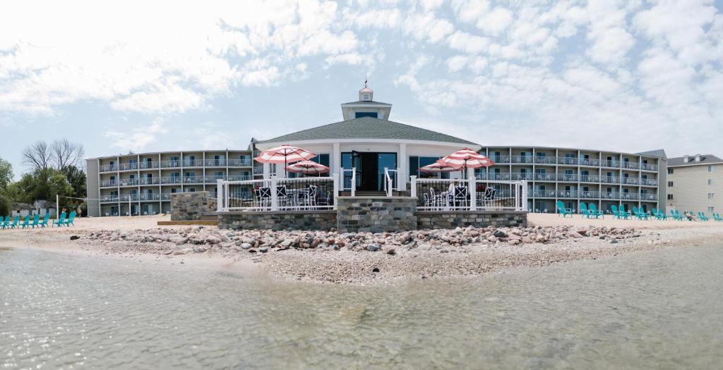 a beach with a large building on top of it at Breakers Resort - Lakeside in Saint Ignace