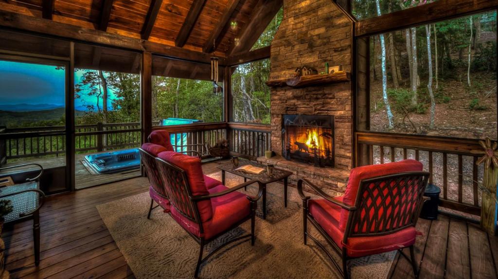 porche cubierto con sillas y chimenea en Above and Beyond, en Blue Ridge