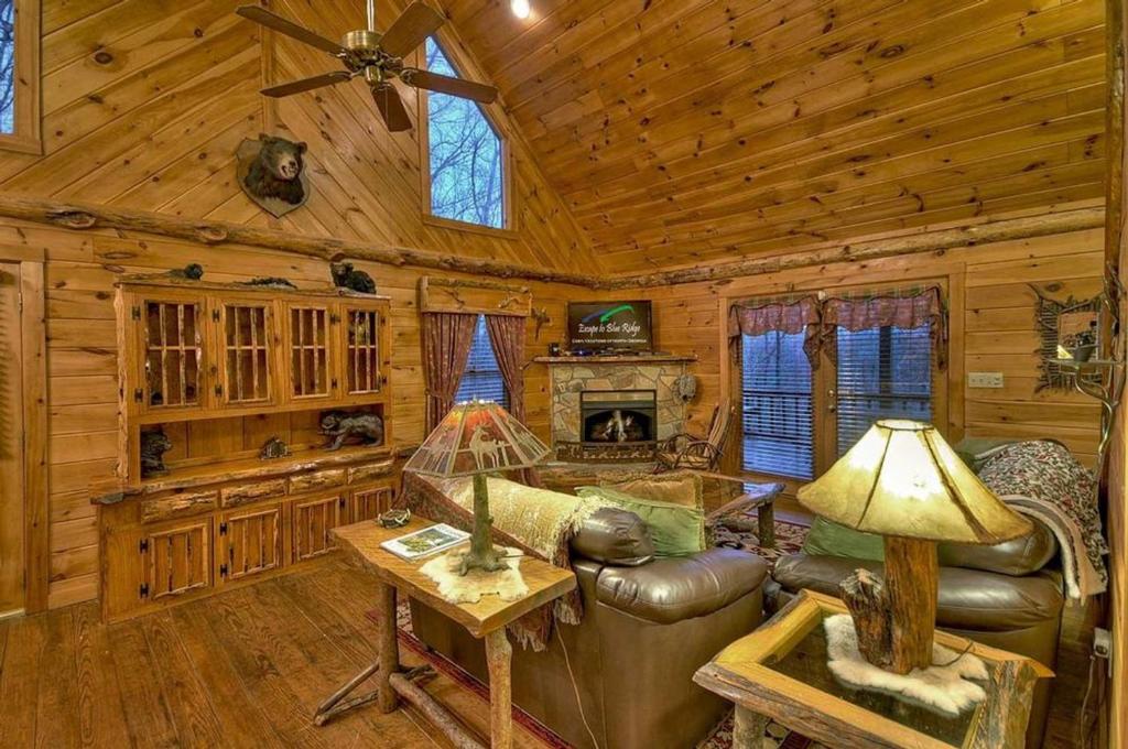 a living room with a couch and a fireplace in a cabin at Big Buck Lodge in Blue Ridge