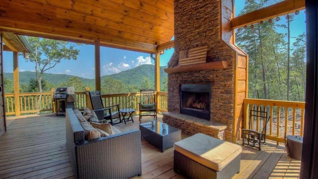 a living room with a fireplace on a deck at Breathe Inn in Blue Ridge
