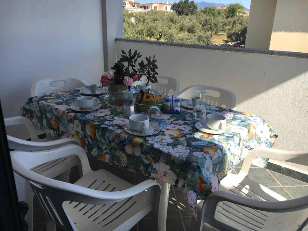 a table with a floral table cloth on a balcony at Sa Domo de Mannoi in Orosei