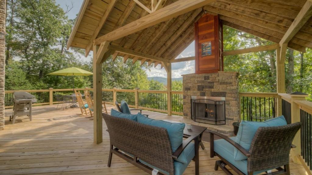 a patio with a fireplace and chairs on a wooden deck at Cubs Cabin in Blue Ridge