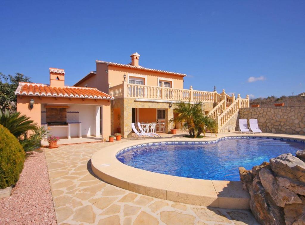 a villa with a swimming pool in front of a house at Villa Gravetes - Plusholidays in Teulada