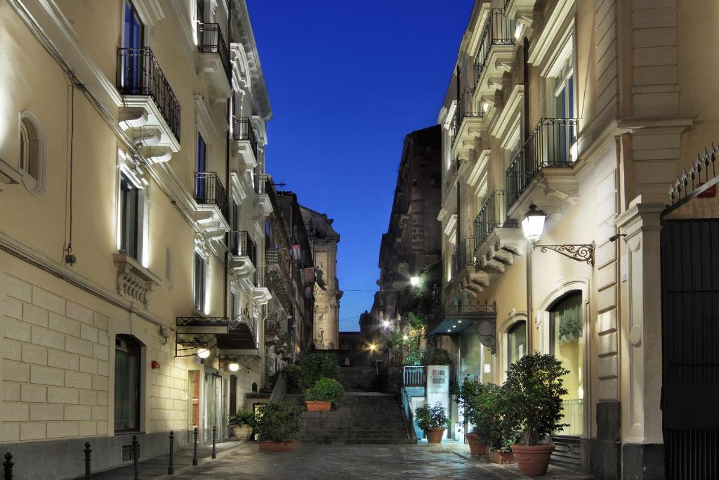 an alleyway between two buildings at night at Il Principe Hotel Catania in Catania