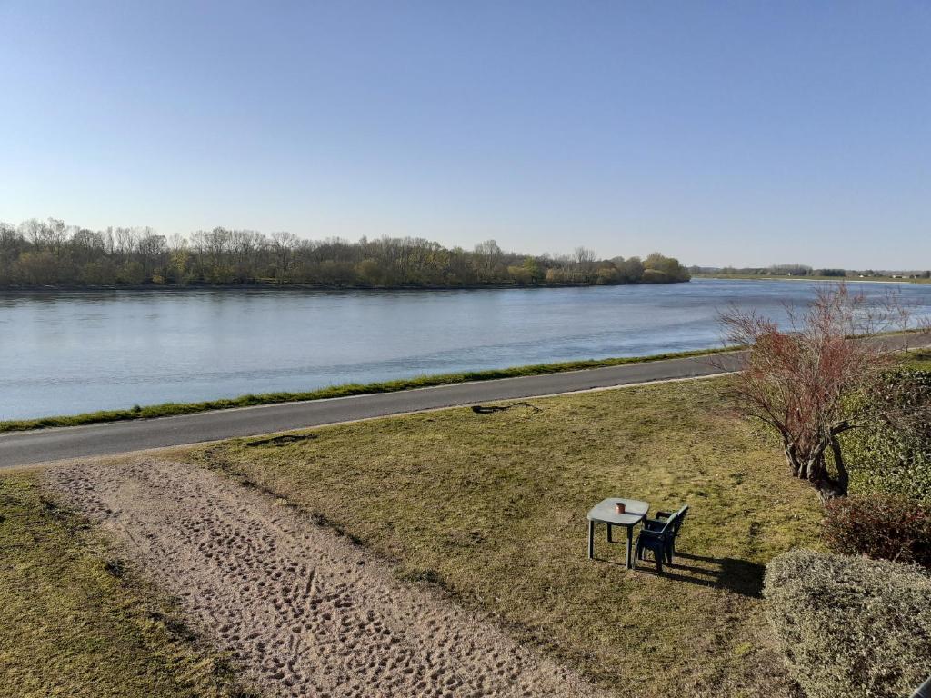 a bench sitting on the side of a road next to a river at Terrasses de Loire 1er étage in Saint-Clément