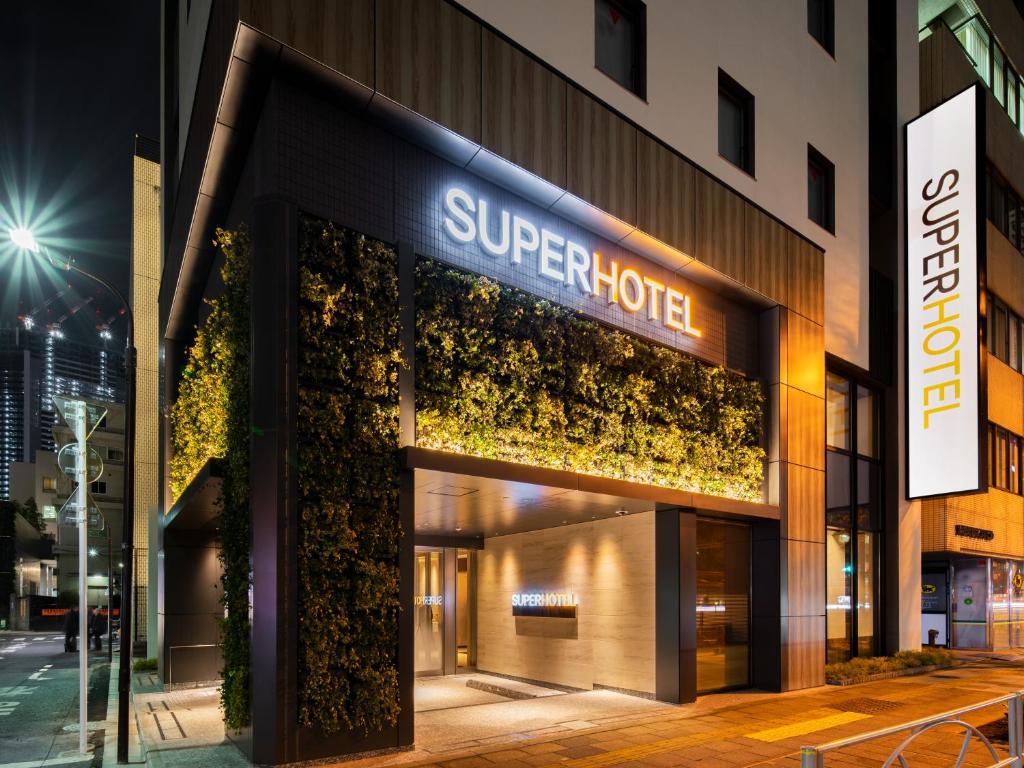 Super Hotel Tokyo Hamamatsucho في طوكيو: محل امام فندق ممتاز بالليل